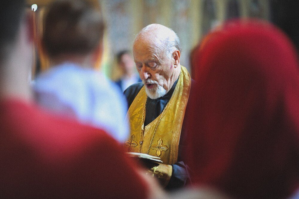 Priester liest ein Gebet aus dem liturgischen Buch in der Kirche