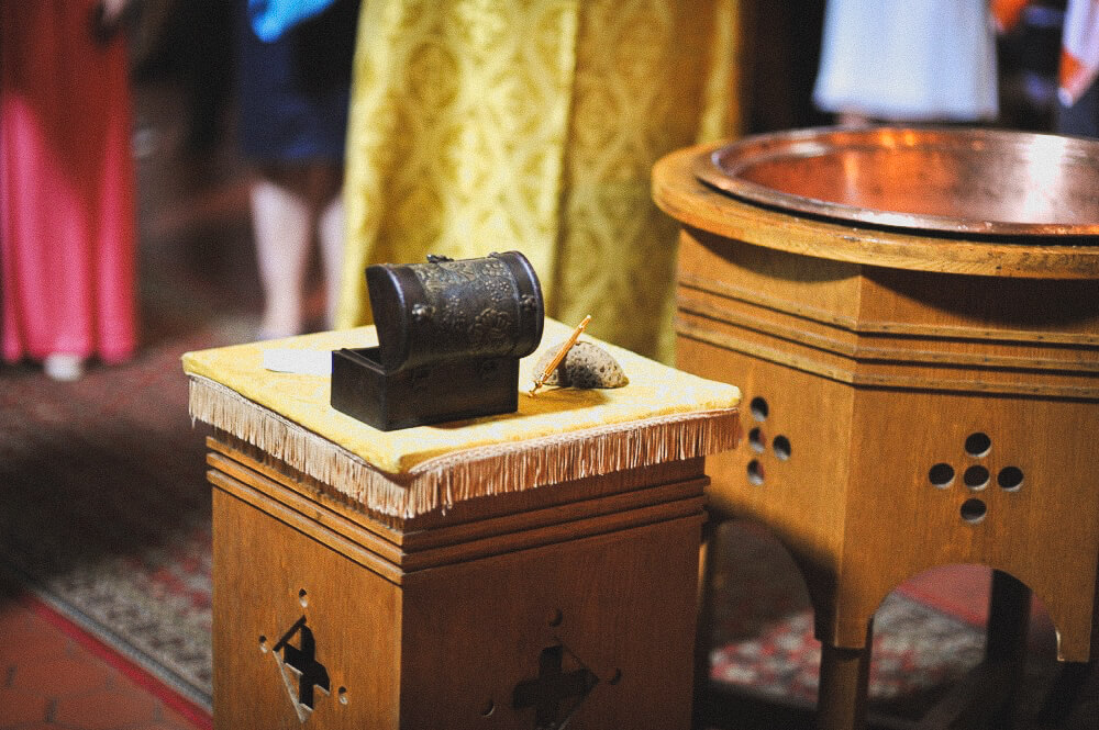 Kirchlicher Ritualbehälter steht auf einem Altartisch neben dem Taufbecken