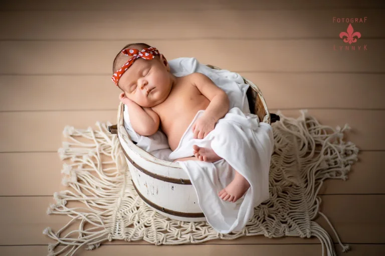 Baby mit rotem Stirnband im Holzbett – professioneller Babyfotograf Frankfurt