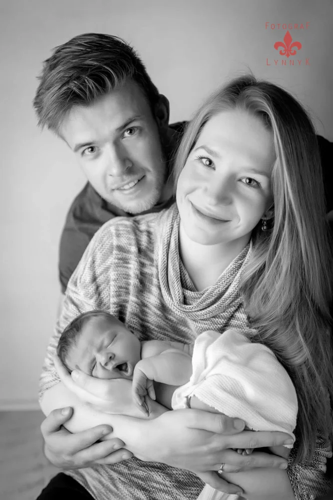 Eltern mit Baby im Schwarz-Weiß-Studio – liebevolle Familienaufnahme.