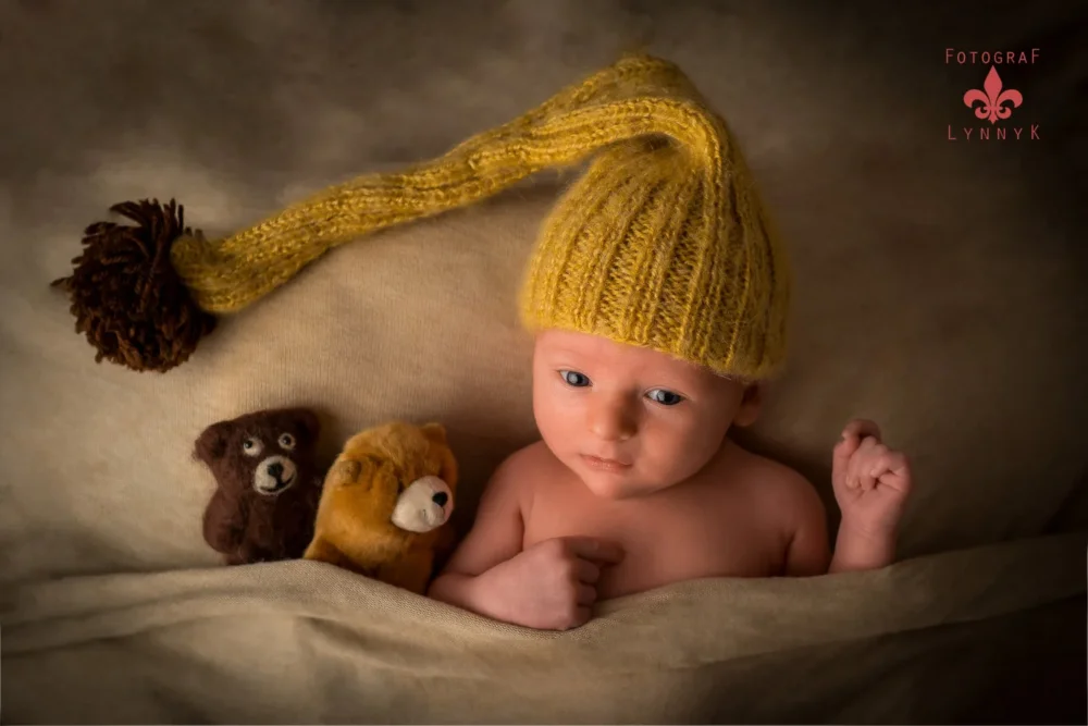 Baby mit gelber Strickmütze und Stofftieren – kreatives Set vom babyfotograf frankfurt